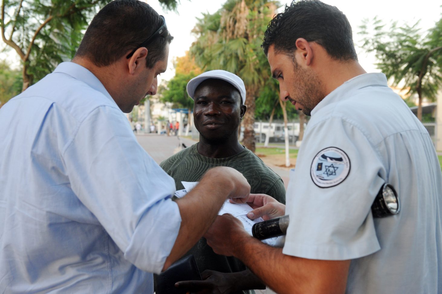An African talking with police officers in Tel Aviv.