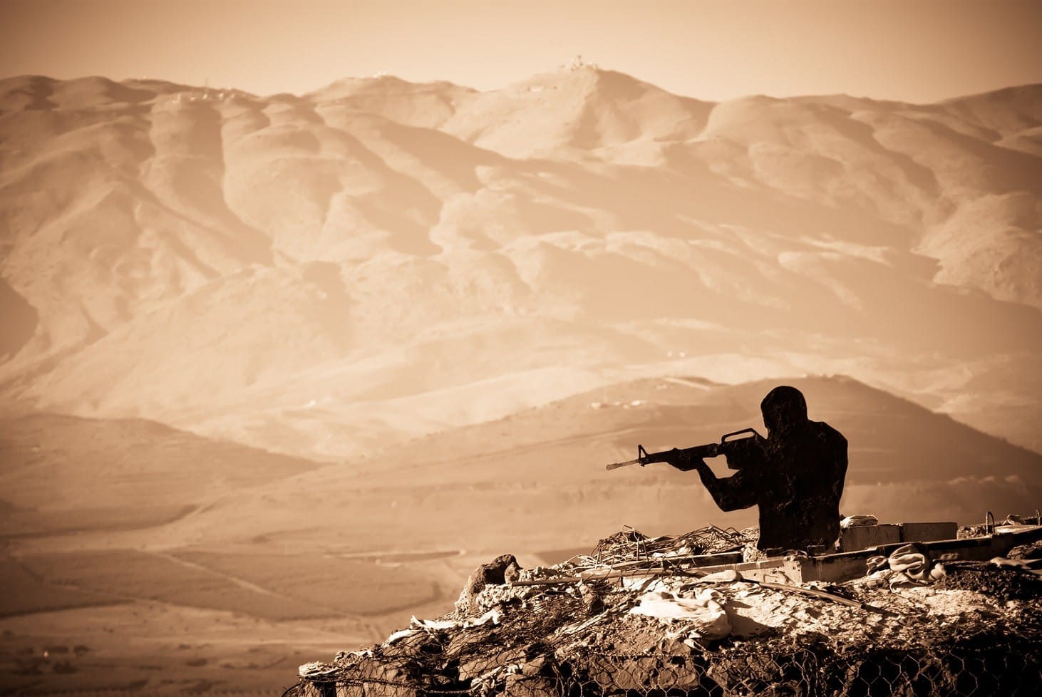 A figure of a Shooting Man with mountains as abackdrop