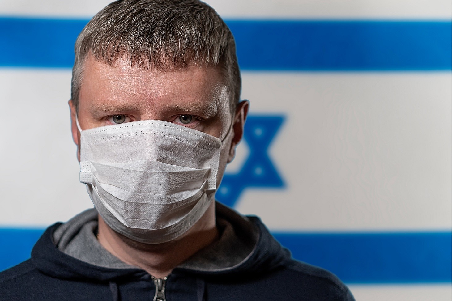 Portrait Of A White Man In A Medical Mask On The Background Of T