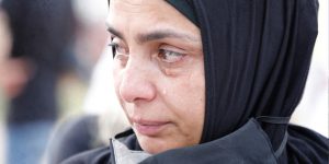 A women in beirut wearing a mask and crying