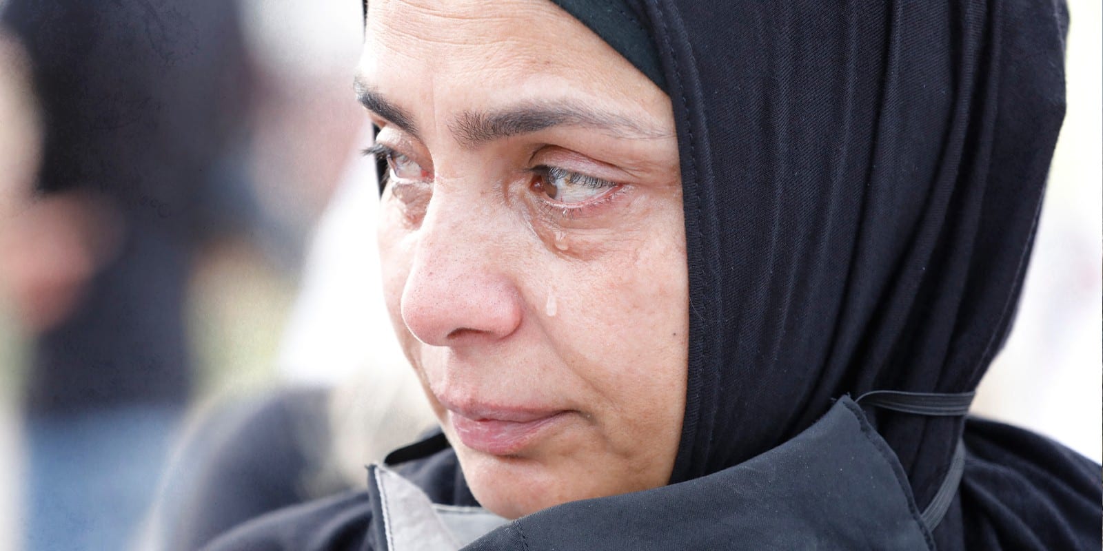 A women in beirut wearing a mask and crying