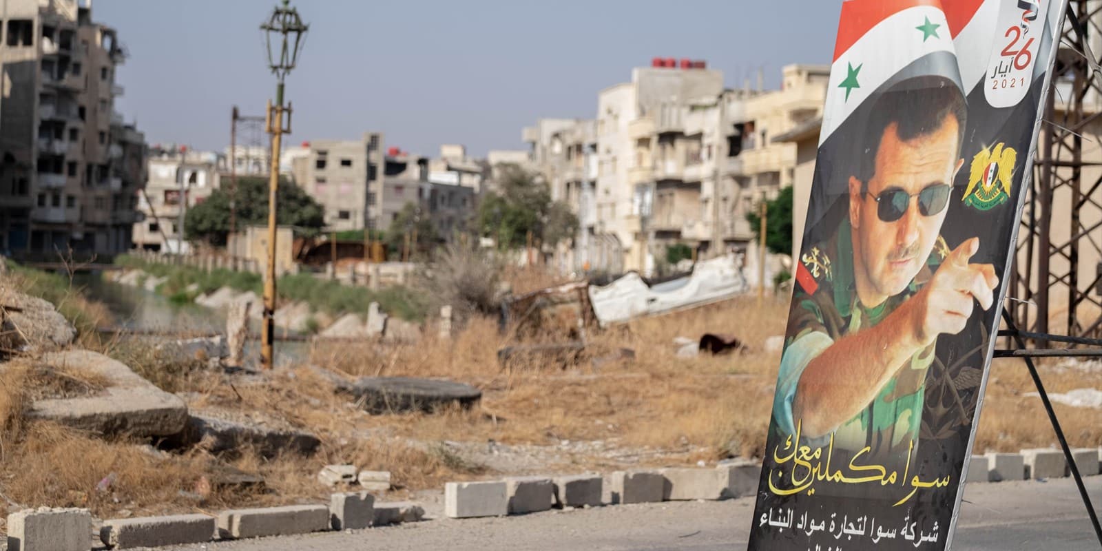 Homs, Syria - August 25, 2021: Poster of Bashar al-Assad in destroyed city center after Syria war.