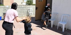An Israeli woman and her daughter are running into a public bomb shelter