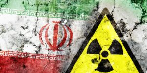 Old cracked wall with radiation warning sign and painted flag, flag of Iran