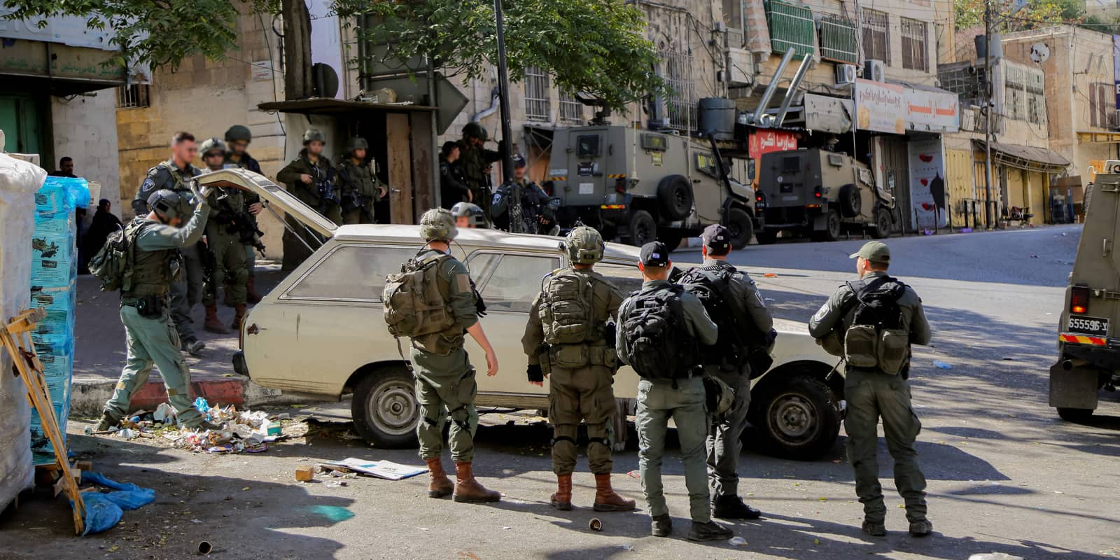 Israeli soldiers stand guard near a street in the old city of Hebron